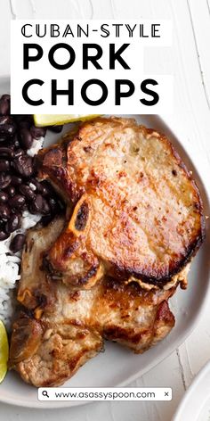 pork chops with black beans, rice and lime on a white plate text reads cuban - style pork chops