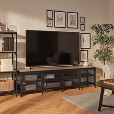 a flat screen tv sitting on top of a wooden entertainment center in a living room