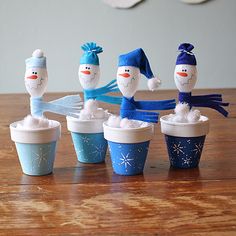 there are many snowmen made out of cupcakes on the table and in cups