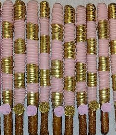 several stacks of gold and pink candy canes are lined up in the same row