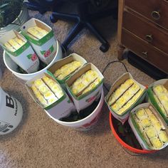 four buckets filled with food sitting on the floor