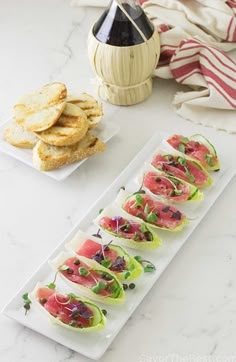 an appetizer plate with watermelon slices and crackers on the side