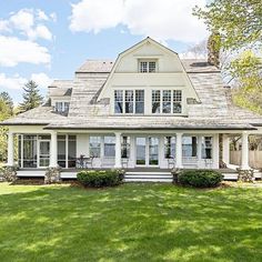 a large white house sitting on top of a lush green field