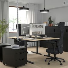 an office with two desks and chairs in front of a window, one has a computer on it