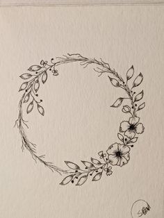 a black and white drawing of a flower wreath