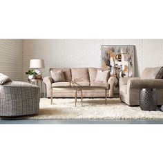 a living room with couches, chairs and a coffee table in front of a brick wall