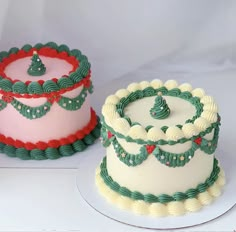 two cakes decorated with green and red icing sitting on top of a white table