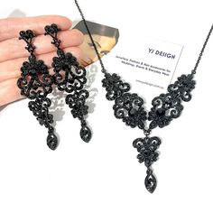 "Gothic black bridal jewelry featuring Victorian wedding Regency vintage stylec chandelier earrings and whimsigoth steampunk statement necklace with ornate damask curls and lace details made of rhinestone crystals in black plating. You may choose earrings only, necklace only or earrings necklace set. Earrings are about 3 3/8\" (8.5cm) long with posts. Necklace total length measures about 17.5\" (44cm). View matching pieces or similar designs at https://etsy.me/3E2xA1t View all Victorian inspired Black Wedding Necklace, Victorian Dangle Chandelier Earrings For Parties, Victorian Chandelier Dangle Earrings For Party, Victorian Style Party Chandelier Earrings, Gothic Dangle Jewelry For Party, Elegant Black Metal Necklace For Weddings, Gothic Dangle Earrings For Party, Black Metal Necklaces For Wedding, Elegant Black Jewelry Set For Wedding