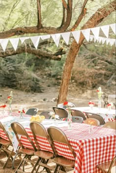 an outdoor table set up with red and white gingham cloths