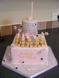 a pink birthday cake with teddy bears on it