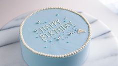 a blue birthday cake with the words happy birthday on it