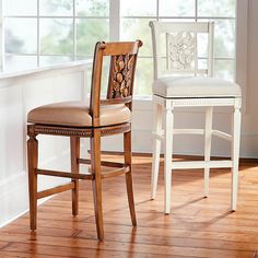 two wooden chairs sitting next to each other on top of a hard wood floor