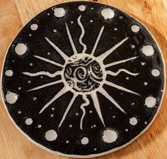 a black and white plate sitting on top of a wooden table