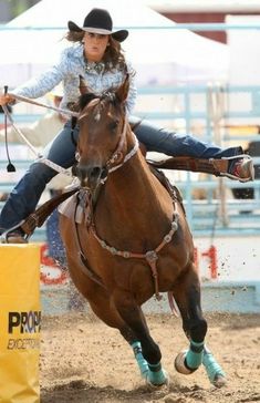 a woman riding on the back of a brown horse