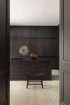 an open door leading to a room with dark wood paneling and wooden furniture in it