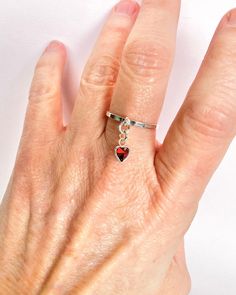 Let your love sparkle with this dainty red cubic zirconia heart charm ring with your choice of a smooth or textured band.  This ring comes in size 5, 6, 7 or 8. ✦100% handcrafted ✦ High quality 925 sterling silver and cubic zirconia ✦ Ring arrives in either a pink microfiber suede envelope/pouch or a blue/green drawer cardboard box as seen in the last image of this listing. ✦ Ready to ship in one business day ✦ Average shipping time (US/Canada/UK) three to five business days  ✦ Tracking available ✦Sterling silver cubic zirconia heart charm Size--5.5x5.5mm Color--red  Shape--heart Material--sterling silver and cubic zirconia ✦Band  Size--2mm Color--silver Style--smooth or textured  Material--sterling silver  ✦Sterling Silver Cleaning Instructions Sterling Silver:  Moisture including water, Green Drawer, Red Heart Ring, Dangle Ring, Envelope Pouch, Silver Cleaning, Charm Ring, Love Sparkle, Cubic Zirconia Rings, Charm Rings