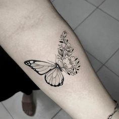 a black and white butterfly tattoo on the arm