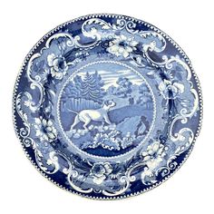 a blue and white plate with an image of animals on it's center piece