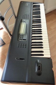 an electronic keyboard sitting on top of a wooden floor