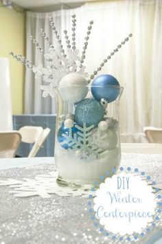 a vase filled with ornaments sitting on top of a table next to a window covered in snow