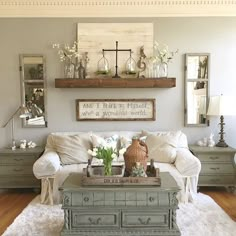 a living room filled with furniture and flowers on top of a coffee table in front of a window