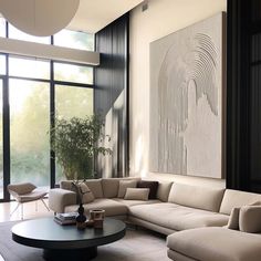 a modern living room with large windows and white couches in front of a painting on the wall