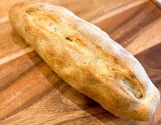 a loaf of bread sitting on top of a wooden cutting board next to a knife