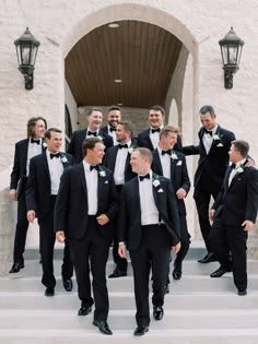 a group of men in tuxedos standing on steps