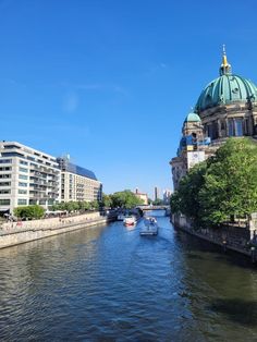 boats are traveling down the river in front of buildings