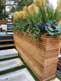 a wooden planter filled with lots of plants