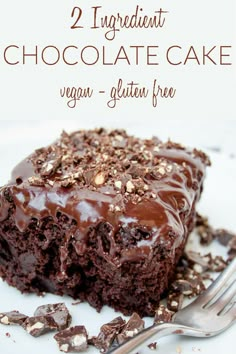 a close up of a piece of cake on a plate with chocolate frosting and nuts