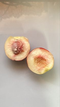 two pieces of fruit sitting on top of a white countertop next to each other