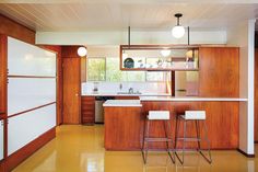 a kitchen with wooden cabinets and white counter tops