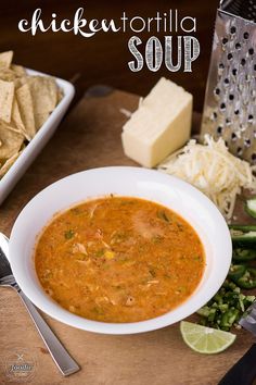 a bowl of chicken tortilla soup next to some chips