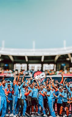 a group of men standing next to each other in front of a crowd holding up their hands