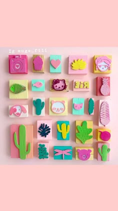 a pink and yellow wall with many different types of paper cut outs on top of it