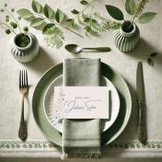 a place setting with napkins, silverware and green plants in vases on the table