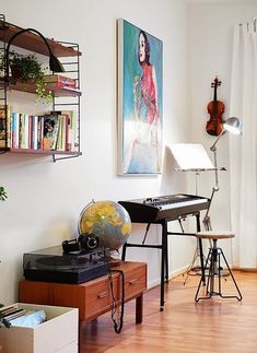 a living room filled with furniture and a painting on the wall next to a desk