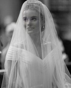 black and white photograph of a woman wearing a wedding dress with veil over her head