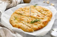 a pizza sitting on top of a white plate next to a cup and saucer