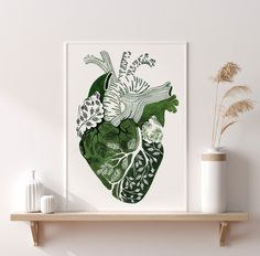 a green and white heart print on a shelf next to a vase with dried flowers