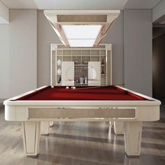 a pool table with a red cloth on it in a room filled with wood floors