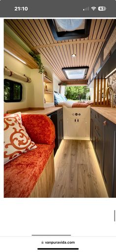 the interior of an rv is shown with wood flooring and red couch in front of it