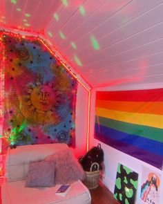 a room with a rainbow wall hanging on the wall and a white couch in front of it