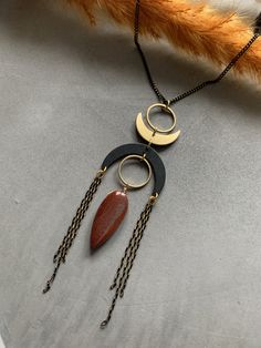 a long necklace with two circular pendants hanging from it's sides