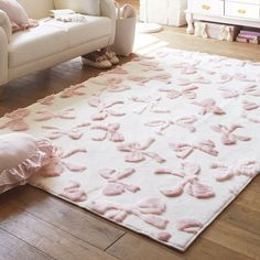 a white couch and pink rug in a room