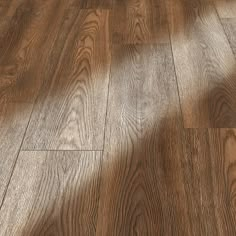 the shadow of a person's hand on a wooden floor