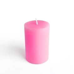 a pink candle sitting on top of a white table