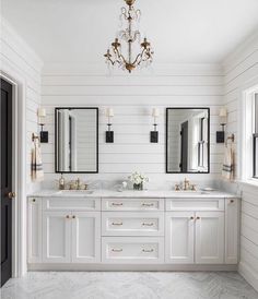 a white bathroom with two sinks and mirrors