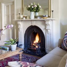 a living room filled with furniture and a fire place in the middle of a fireplace